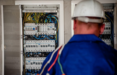 : An image of a maintenance worker examining the fuse box.