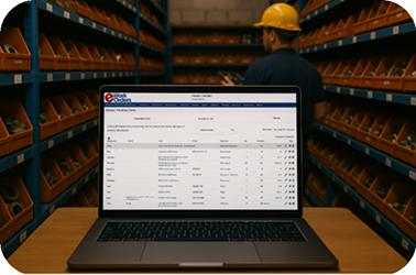 Maintenance technician managing spare parts inventory with eWorkOrders CMMS on a laptop in a parts storage room.