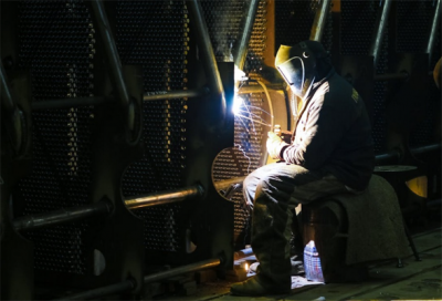 An image of a worker reinforcing equipment through welding. 